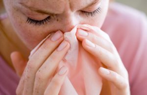 Woman blowing nose