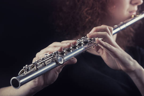 Close-up of a woman playing the flute. Musical concept
